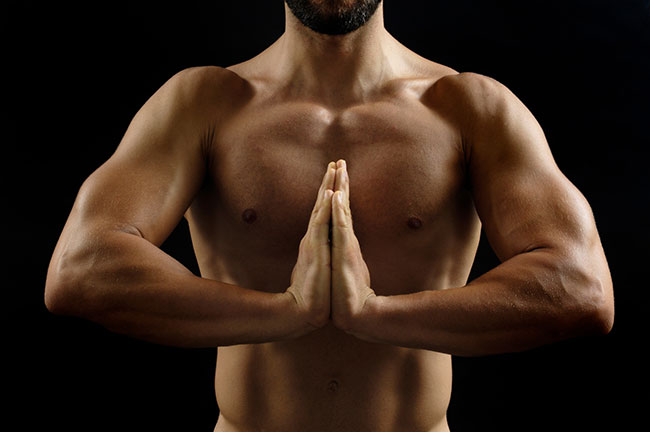 Mann meditiert mit Handflächen aufeinander